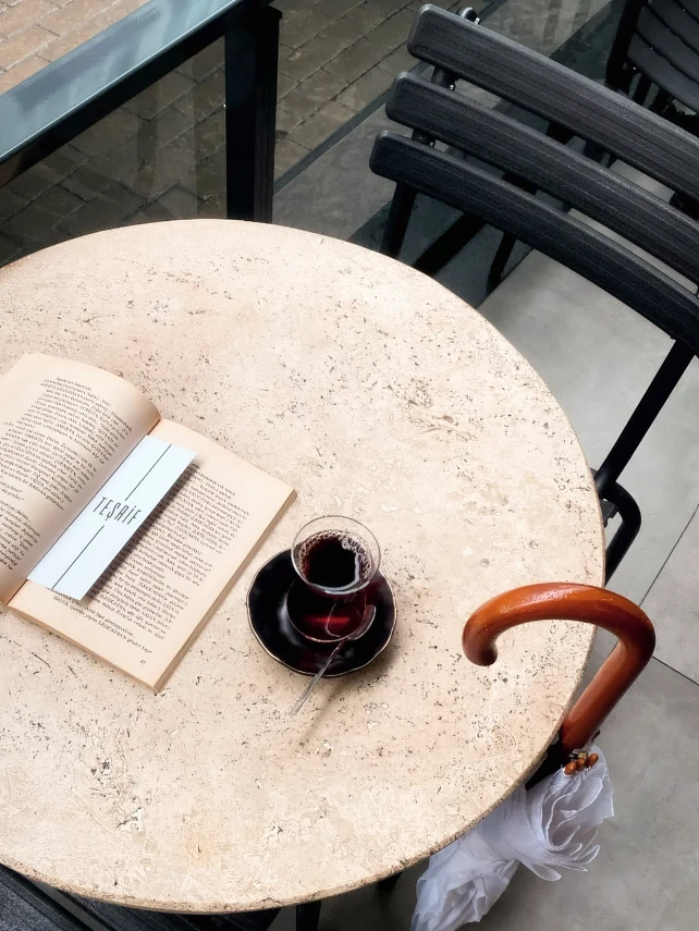 Mermer masada açık kitap, Teşrif ayracı ve ince belli bardakta çay